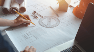 Plan dun bâtiment dessinné avec un rapporteur, un compas et un crayon